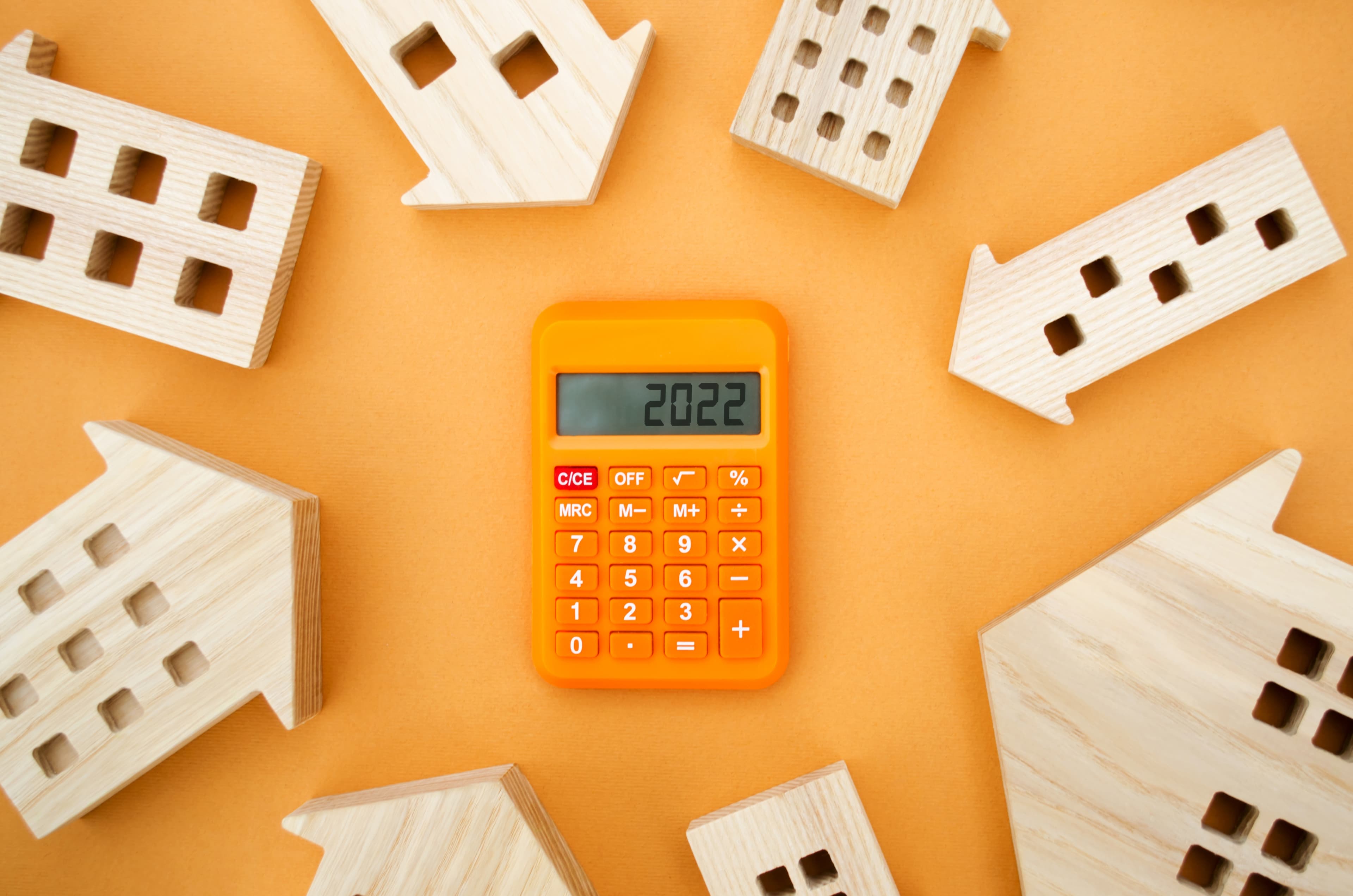 Real estate calculator tool with wooden house models used for rental property deal analysis