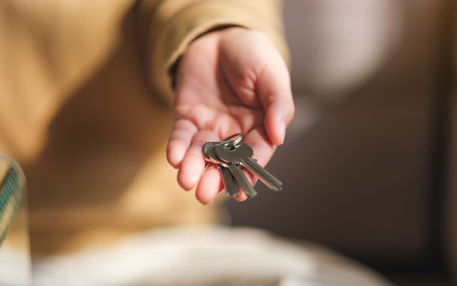 Hand holding house keys after a successful real estate closing