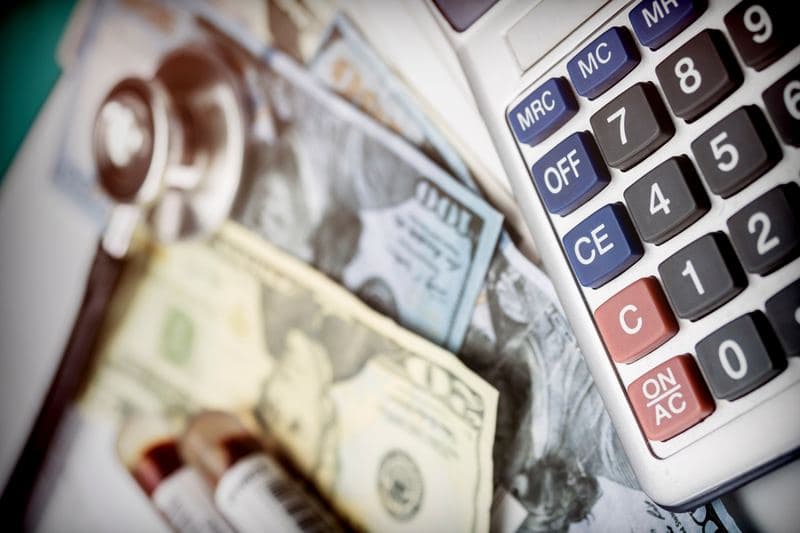 Stethoscope and money representing the financial health metrics cap rate and cash-on-cash return for rental properties